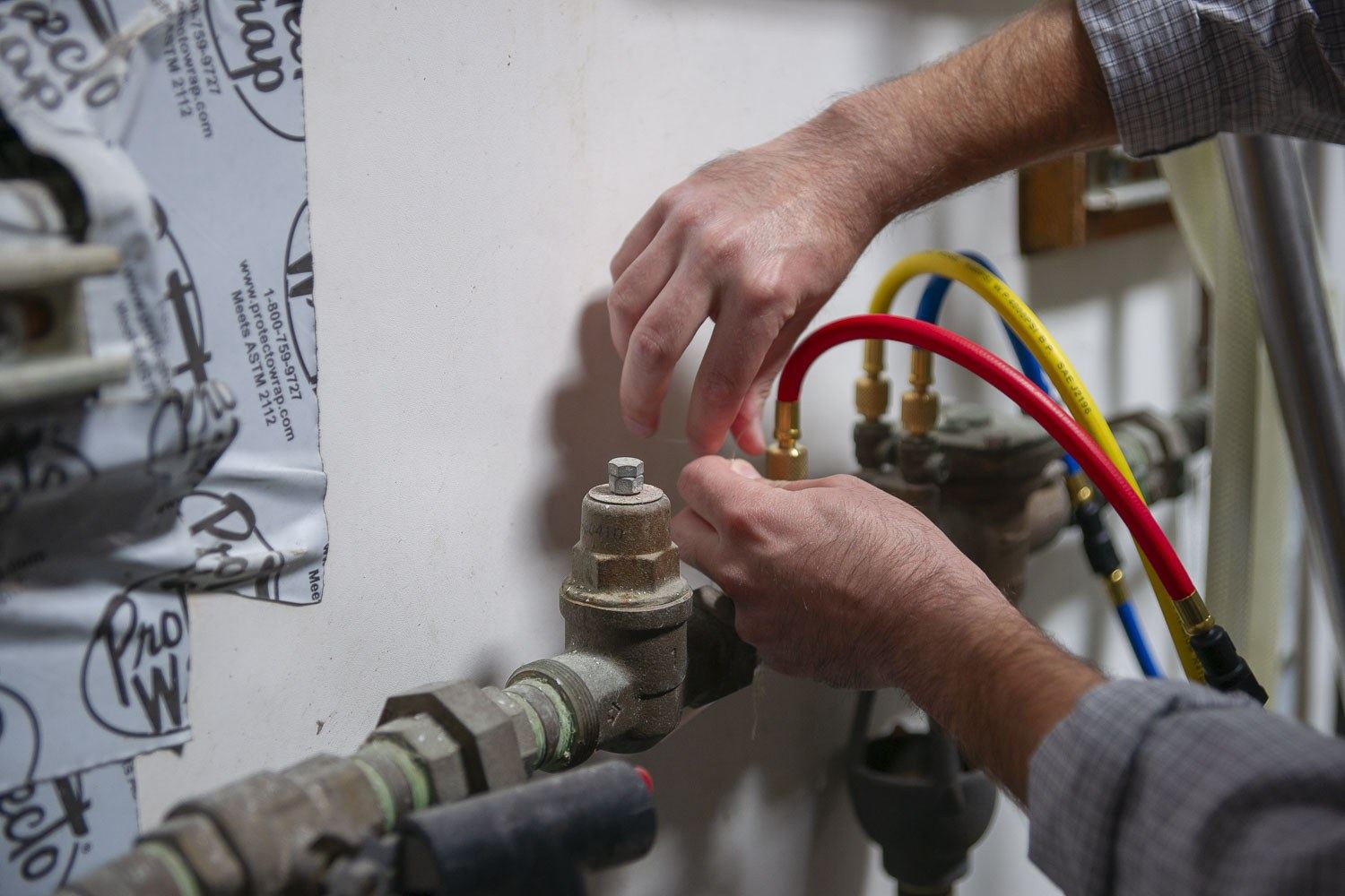 Test hoses attached to a brass backflow prevention assembly