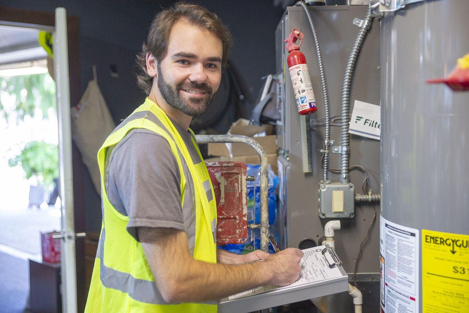 Technician smiling while completing an on-site inspection
